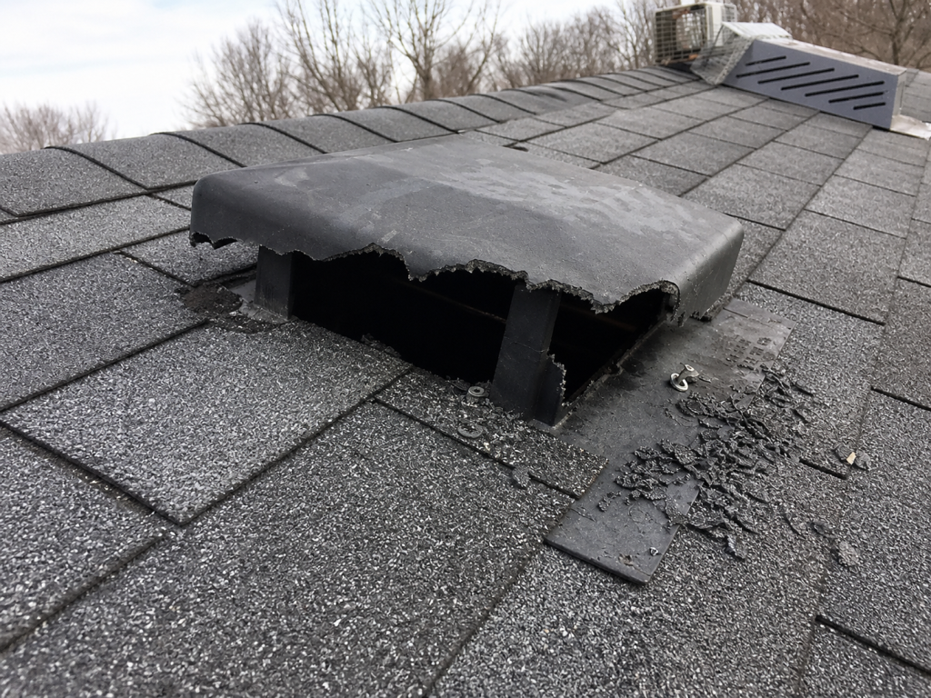 A broken vent on the roof of a house.