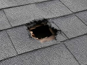 A hole in the shingles of a roof.